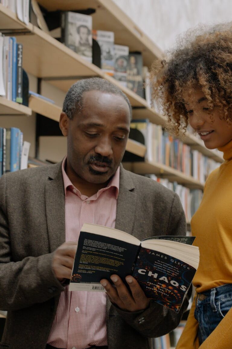 Man in Yellow Sweater Holding Book Beside Woman in Brown Sweater